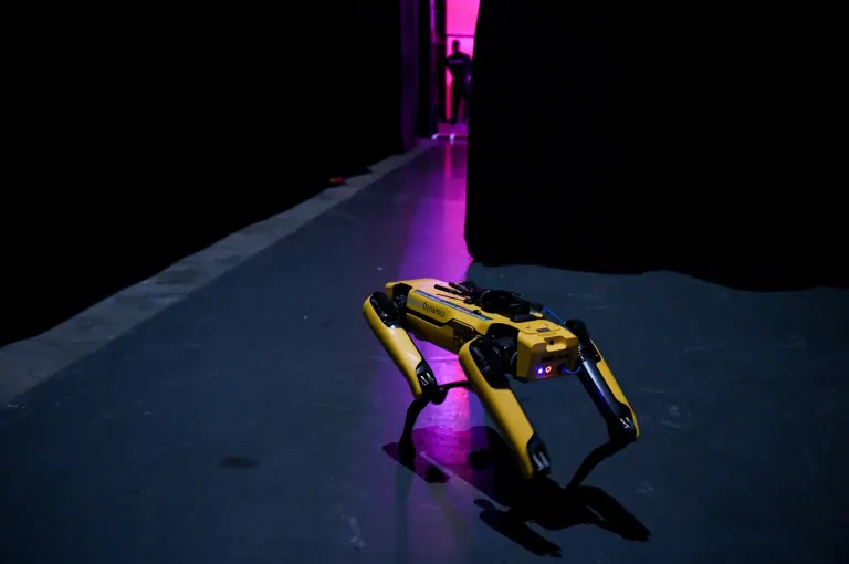 Boston Dynamics SpotMini quadruped robot standing on a stage floor