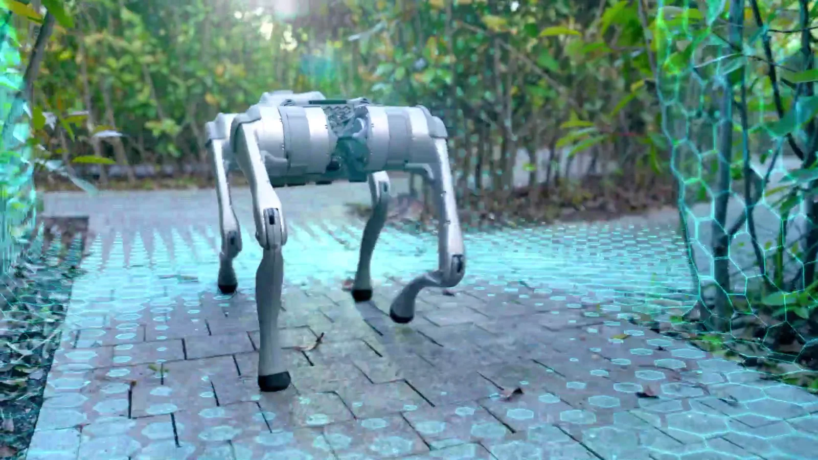 Quadruped patrol robot walking a paved garden path between hedges